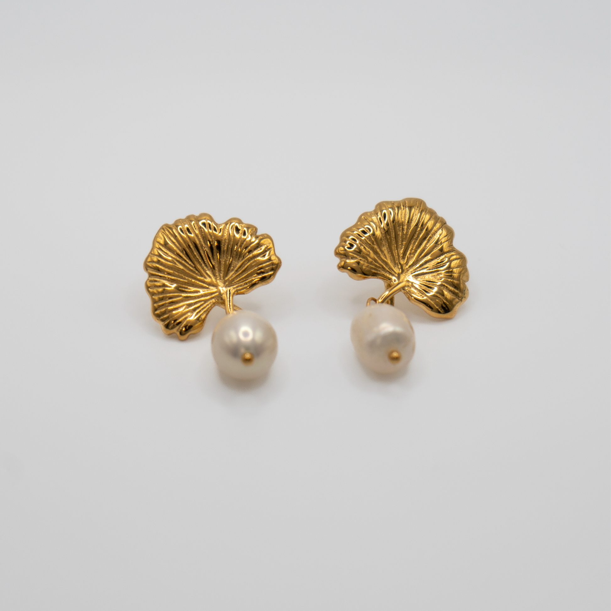 Lula Sea jewellery Ginkgo Pearl Drop earrings, a gold plated ginkgo Leaf stud earring that covers the ear lobe, with a single fresh water pearl drop dangling from-the bas of its stem.