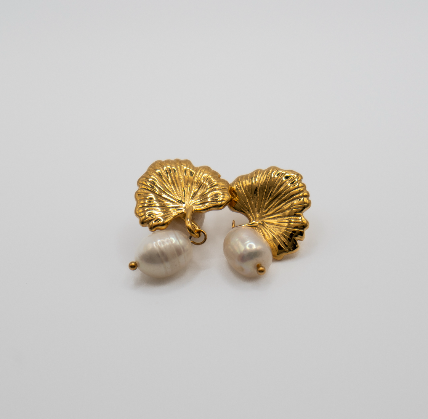 Lula Sea jewellery Ginkgo Pearl Drop earrings, a gold plated ginkgo Leaf stud earring that covers the ear lobe, with a single fresh water pearl drop dangling from-the bas of its stem.zoomed view
