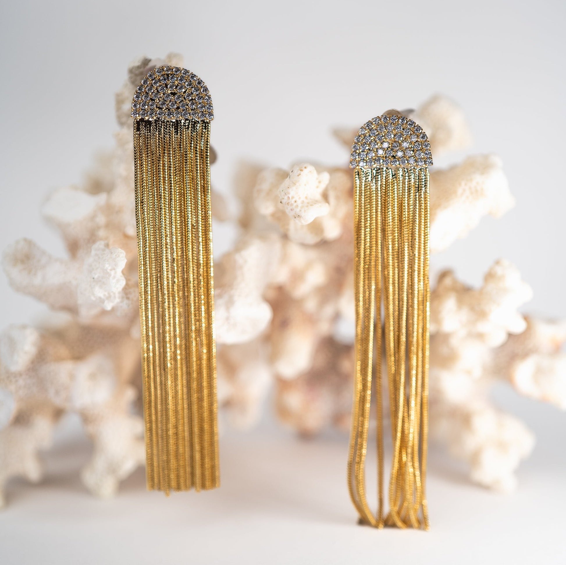 Lula Sea Tassel Jellie Studs, feature chain tassel hanging from a diamanté arch,  statement earrings,  pictured hanging from a piece of coral