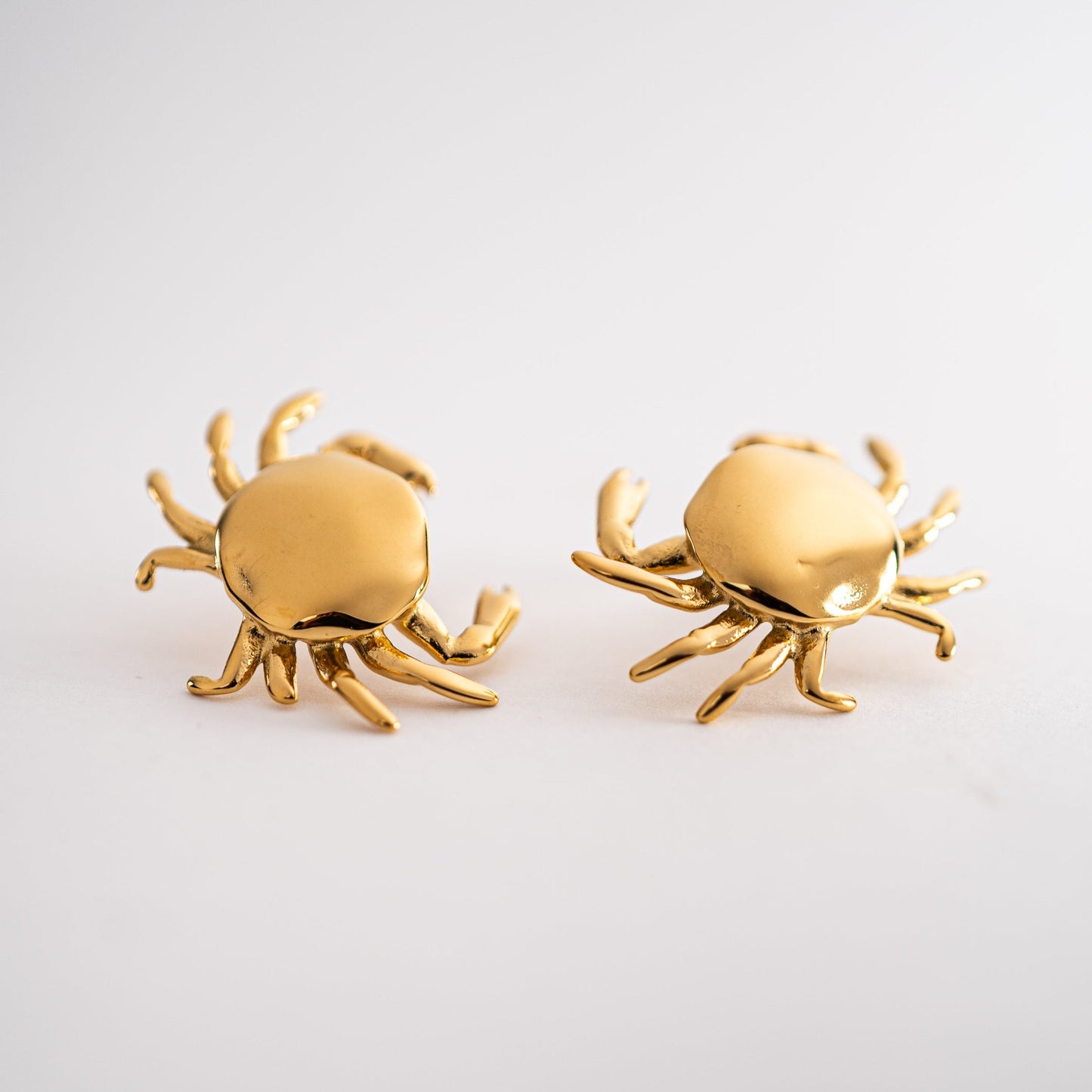 Lula Sea Jewellery, statesment earrings, 18k gold plated pincer stud earrings, small golden crab earrings, studs earrings, crab hangs from one pincer attached to the stud. Lula Sea Jewellery New Zealand 