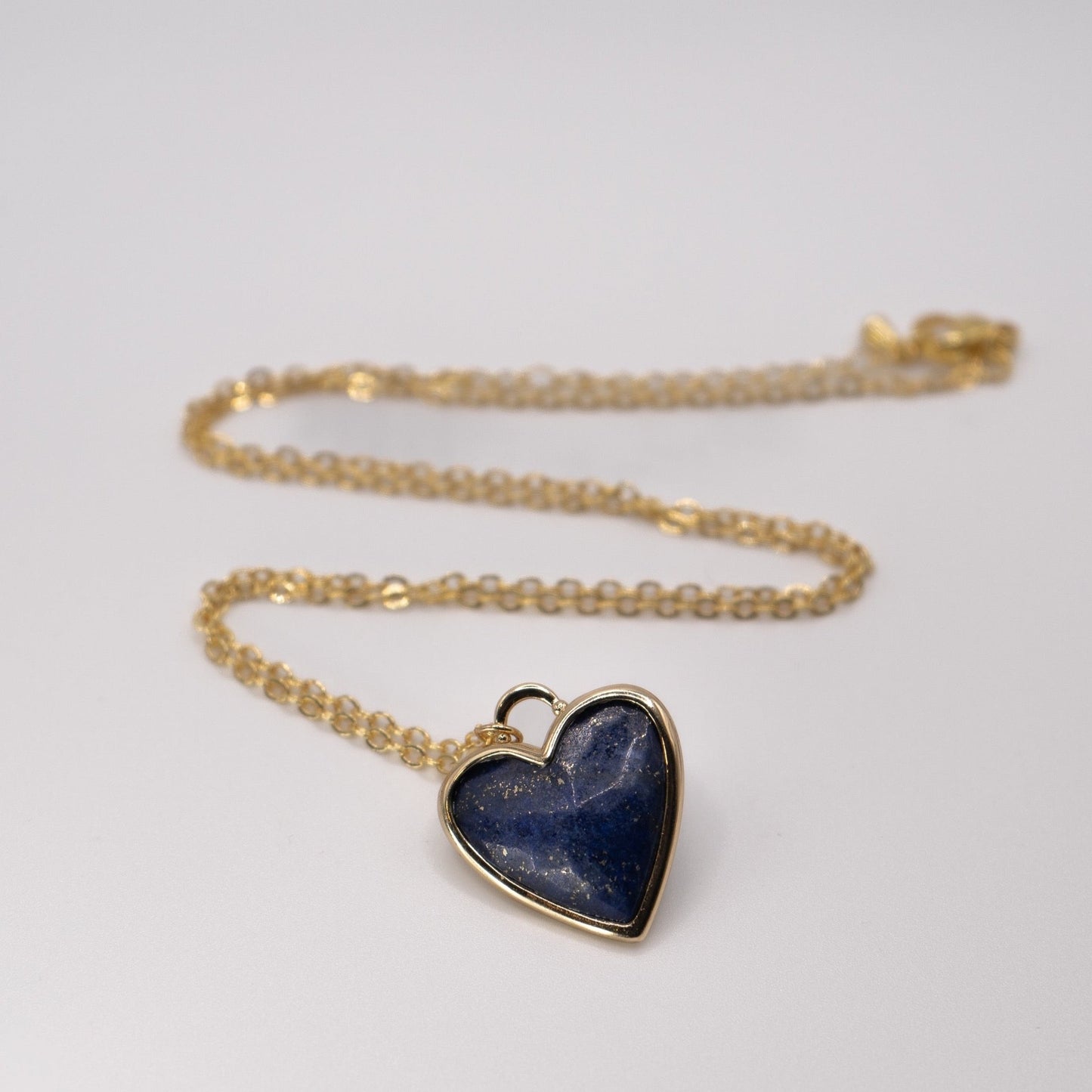 Lula sea Jewellery New Zealand Lapis heart pendant necklace, made from 18k gold and natural facet cut gem stone, vermeil, pictured laying on flat surface