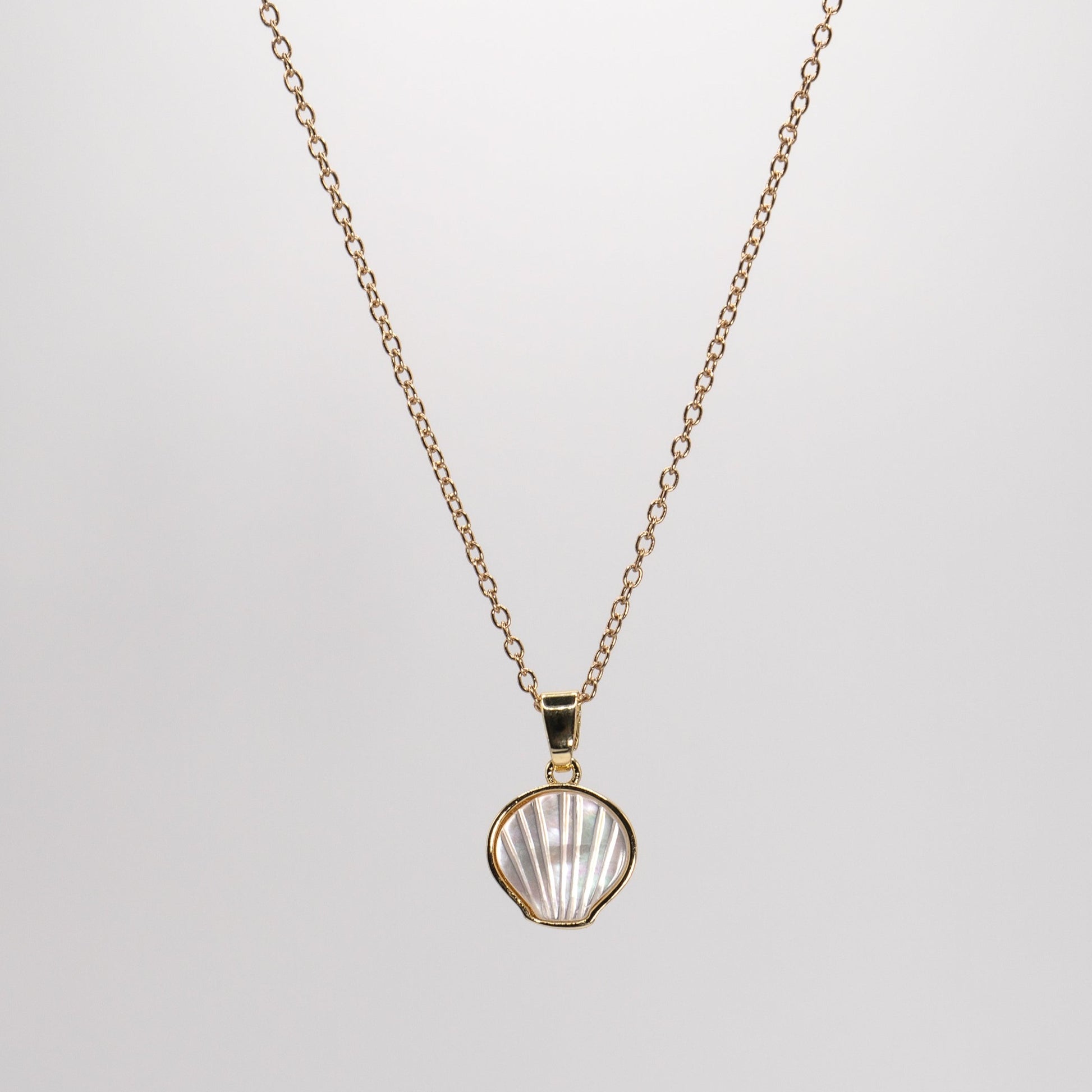 Lula Sea’s sweet scallop shell pendant necklace , carved from beautiful iridescent shell and incased in a 18k gold plated setting, pictured hanging