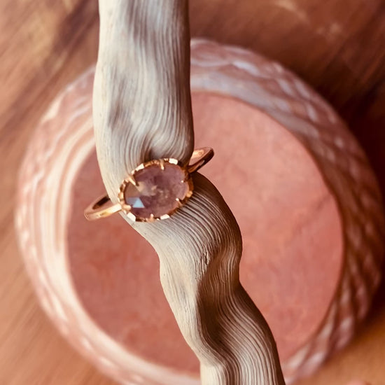 Lula Sea Jewellery New Zealand, Sugarplum ring, video of on a pice of drift wood, slowly turning in the light showing the blue flash of the strawberry labradorite faucet cut gemstone. Ring made from Gold vermeil